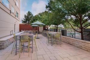an outdoor patio with tables and chairs and trees at Element Houston Vintage Park in Houston