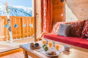 a living room with a table with food on it at Lagrange Vacances Le Grand Panorama II in Valmeinier