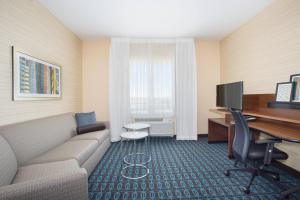 a living room with a couch and a desk with a computer at Fairfield Inn & Suites by Marriott Burlington in Burlington +21 photos