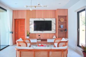 a living room with a couch and a tv at Villa Nadsuree Ao-Nang Luxury Modern House in Ao Nang 