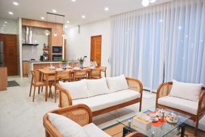 a living room with a table and chairs and a kitchen at Villa Nadsuree Ao-Nang Luxury Modern House in Ao Nang 