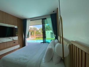 a bedroom with a bed with a view of a pool at Villa Nadsuree Ao-Nang Luxury Modern House in Ao Nang  +87 photos