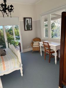 une chambre avec un lit, un bureau et une table dans l'établissement Bylands Cottage Historic Home - Tambo river views and pet friendly, à Swan Reach