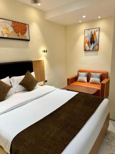 a bedroom with a large bed and a chair at HOTEL TOUCHWOOD in Visakhapatnam