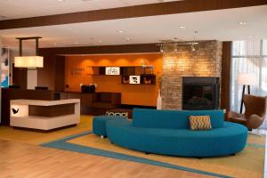 デュランゴにあるFairfield Inn & Suites by Marriott Durangoの青いソファと暖炉のあるリビングルーム