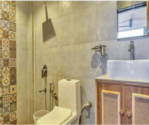 a bathroom with a toilet and a sink at The Luma House-TBV in Baga