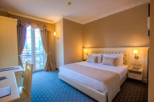 a hotel room with a large bed and a large window at Lot Boutique Hotel by Hotels and Préférence in Tirana