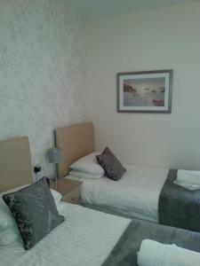 A bed or beds in a room at Hafan-y-Mor Guesthouse 