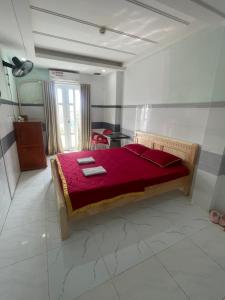 Khách Sạn Kim Thanh في مدينة هوشي منه: غرفة نوم مع سرير مع لحاف احمر