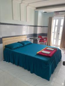 Khách Sạn Kim Thanh في مدينة هوشي منه: غرفة نوم بسرير ازرق مع بطانيه حمراء