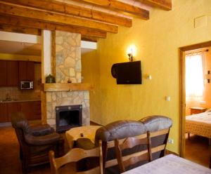 ein Wohnzimmer mit Kamin, Tisch und Stühlen in der Unterkunft Casa Rural Arroyo Rechita in La Iruela