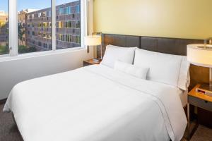 a white bed in a hotel room with a window at Element Miami International Airport in Miami