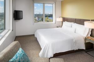 a hotel room with a large white bed and windows at Element Miami International Airport in Miami