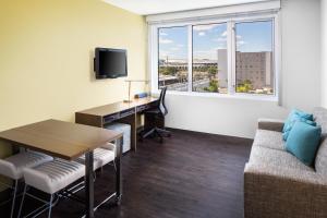 a living room with a table and a desk with a computer at Element Miami International Airport in Miami