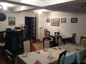 een eetkamer met tafels en stoelen met witte tafellakens bij Pensiunea Kenza in Târgu-Mureş