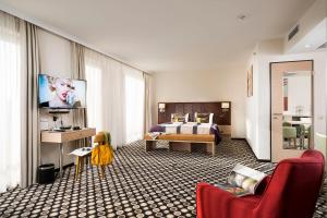 a hotel room with a bed and a television at Bo33 Hotel Family & Suites in Budapest
