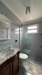 Et badeværelse på Aconchegante apartamento 2 dormitórios no centro com vaga