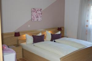 a bedroom with two beds with purple and white pillows at Hotel Karlshof in Karlsdorf-Neuthard