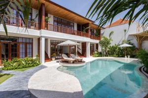 a villa with a swimming pool and a house at Plawa Laguna Bali - Boutique Hotel & Suites in Canggu +46 photos