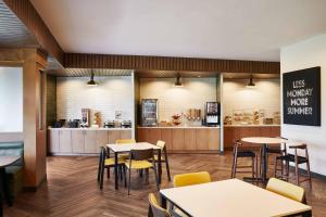 a restaurant with tables and chairs and a counter at Fairfield Inn & Suites by Marriott Kansas City Belton in Belton
