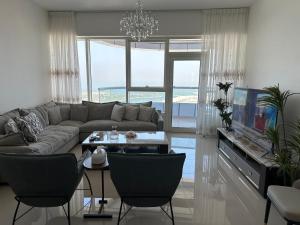 シャルジャにあるCloudsのソファとテレビのあるリビングルーム