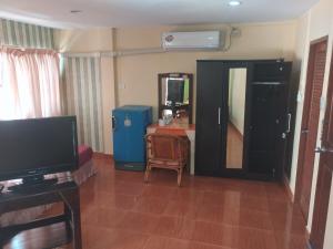a living room with a television and a table with a chair at SleeproomsHuahin in Hua Hin