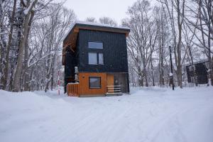 a small house in the snow in a forest at Koyo Onsen Chalet in Niseko