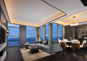 uma sala de estar com um sofá e uma mesa em Wanda Yi Hotel Chengdu em Chengdu