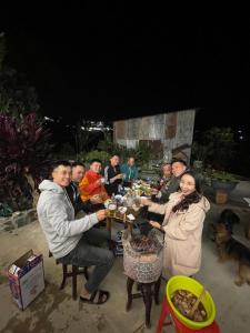 a group of people sitting around a table eating at Home stay Thương Thương in Xuan An