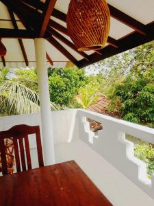a porch with a table and a chandelier at Serendib Villa in Ahangama