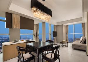 uma cozinha e sala de estar com mesa e cadeiras em Wanda Yi Hotel Chengdu em Chengdu