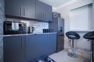 a kitchen with blue cabinets and a microwave at Cape Dreamland in Cape Town