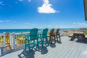 a deck with chairs and a picnic table and the ocean at 7083 - Ocean Haven in Nags Head