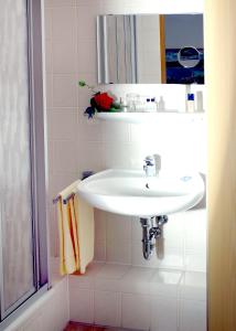 y baño con lavabo blanco y espejo. en Hotel Karlshof, en Karlsdorf-Neuthard