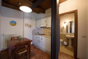 uma cozinha com uma mesa, um lavatório e um WC em Borgotufi Albergo Diffuso em Castel del Giudice