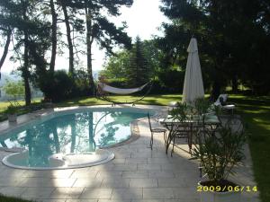 una piscina con sombrilla, mesa y sillas en Domaine du Bouloy, en Druyes-les-Belles-Fontaines 17 fotos más