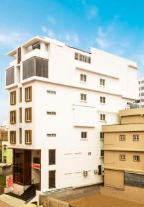 a white apartment building with a balcony at The Hoften Sterling Plaza Near Kempegowda International Airport in Bengaluru