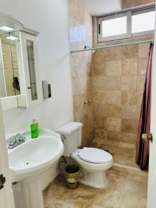 a bathroom with a white toilet and a sink at Quinta Frida in Oaxtepec +12 photos