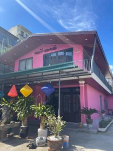 a pink building with a balcony on top of it at Home stay Thương Thương in Xuan An