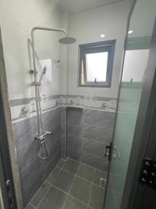 a bathroom with a shower with a glass door at Home stay Thương Thương in Xuan An
