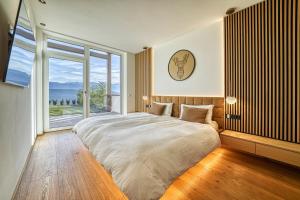 Un dormitorio con una cama grande y una ventana grande. en Luxury house with panoramic view & hot tub, en Caldaro