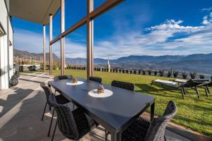 Una mesa y sillas en un patio con vista. en Luxury house with panoramic view & hot tub, en Caldaro