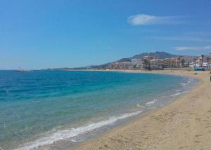 a beach with blue water and buildings in the background at Precioso y luminoso apartamento junto al mar y playa en Garrucha 1B in Garrucha +4 photos