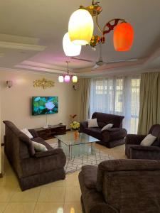 a living room with two couches and a tv at MichMal Homes in Mombasa