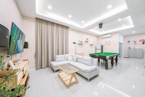a living room with a couch and a pool table at Homey House Na Jomtien in Na Jomtien