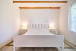 - un lit blanc dans une chambre avec 2 tables de chevet dans l'établissement Finja, à Fuhlendorf