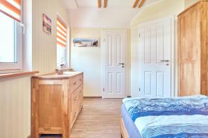 une chambre avec un lit, une commode et une fenêtre dans l'établissement Findus, à Fuhlendorf