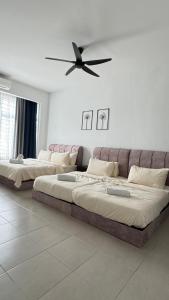 two beds in a room with a couch and a ceiling fan at LestariHome1, KLIA Sepang in Sepang