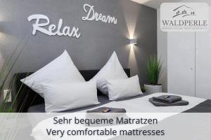 a room with a bed with white pillows at Exklusives 5-Sterne Apartment Waldperle mit Indoor-Pool, Sauna, top Lage und Ausblick in die Natur, Hunde willkommen in Schonach