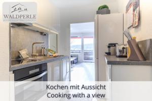 a kitchen with a kitchen hitartist cooking with a view at Exklusives 5-Sterne Apartment Waldperle mit Indoor-Pool, Sauna, top Lage und Ausblick in die Natur, Hunde willkommen in Schonach +43 photos